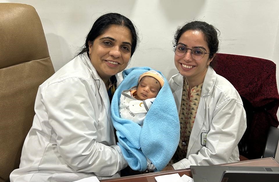 Our doctors with a newborn at PRAVI IVF Kanpur